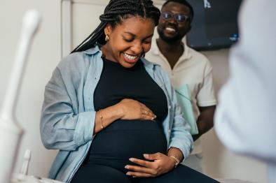 Pregnant woman looking happily at her belly.