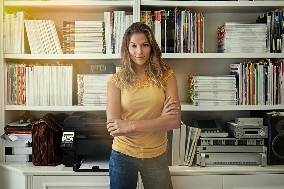 Confident woman standing in front of bookcase