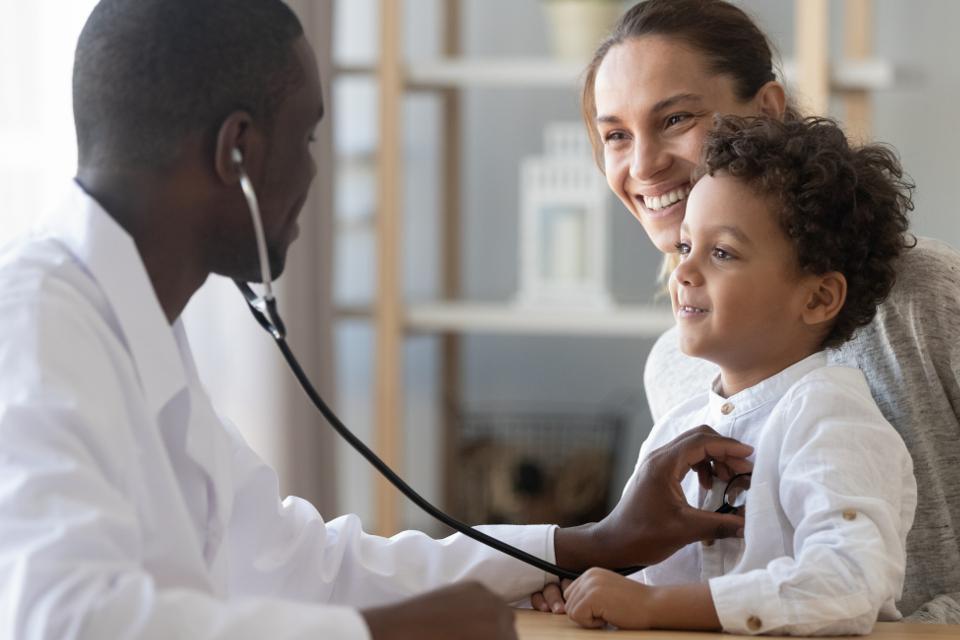 a doctor tends to a child heald by his mother