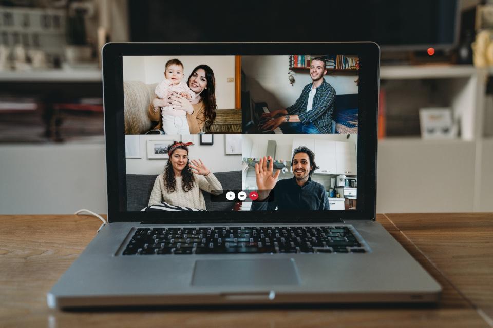 A group of people use a video chat to greet each other on the computer