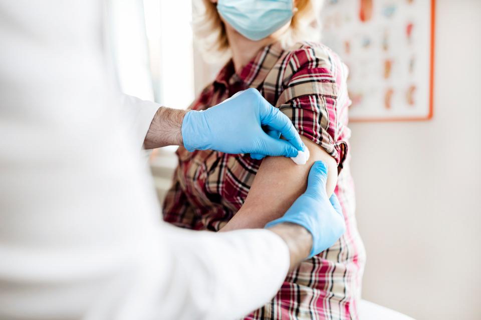 a doctor swabs a woman's arm for a flu vaccine shot