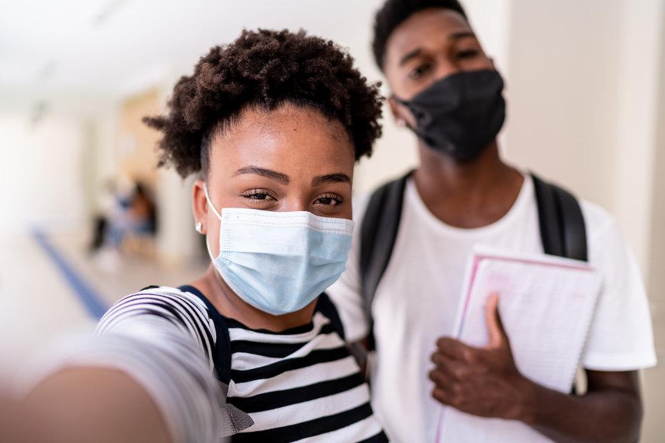 Two young students dawn masks as they return to school