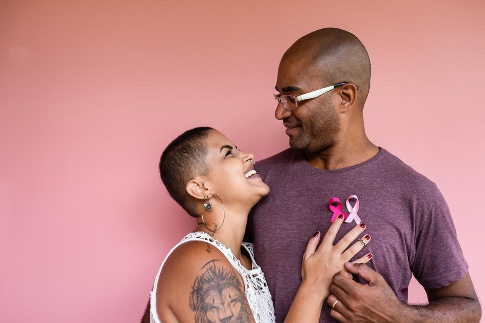 A woman looking up at a man with her hand on his heart