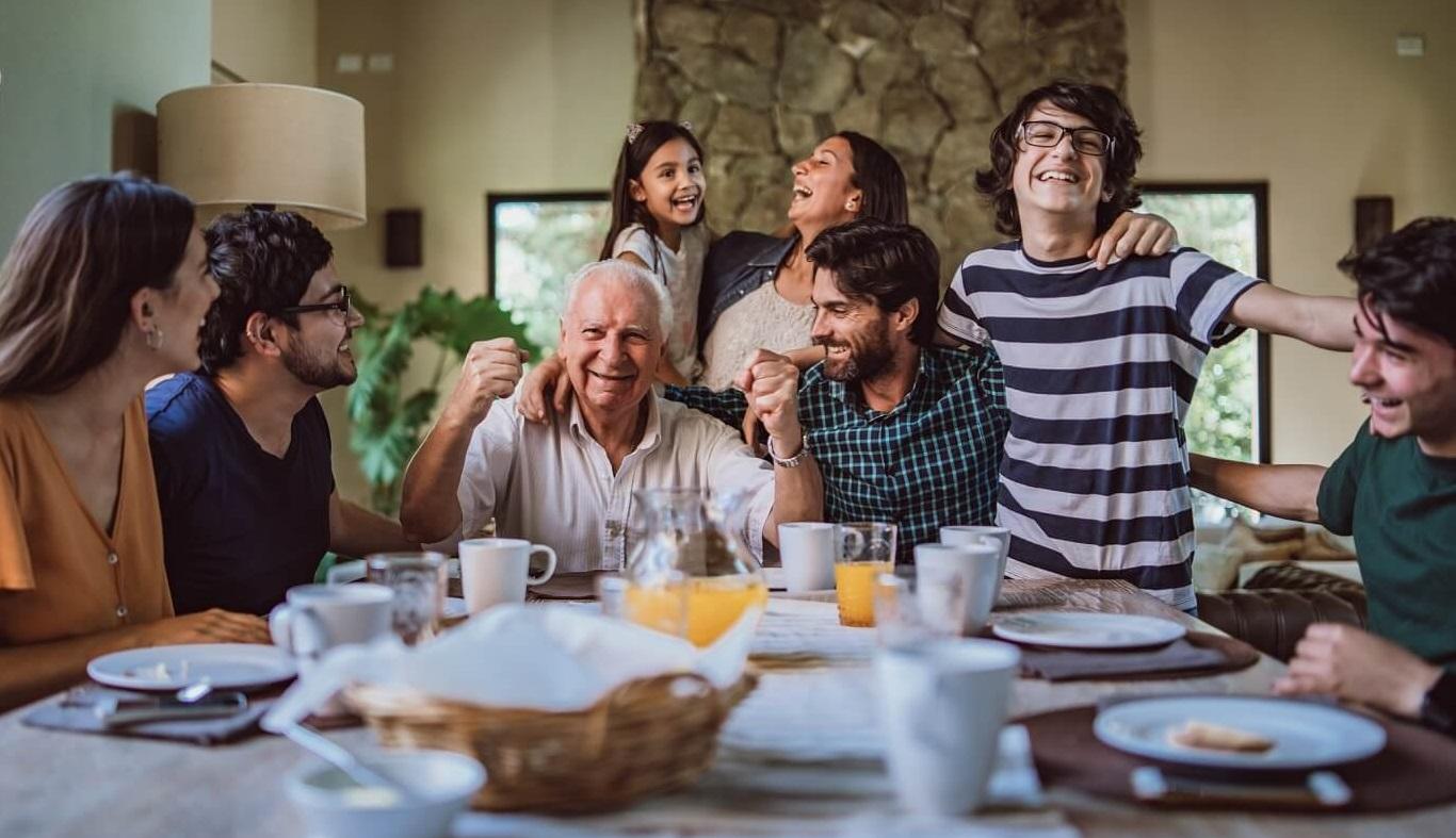 Photo of happy, multigenerational family at dinner table.