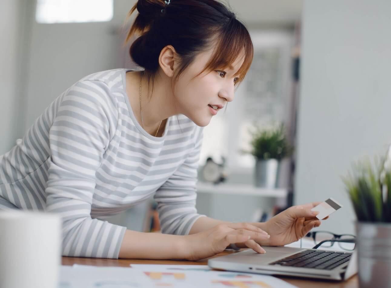 Photo of young woman paying bills on her laptop.