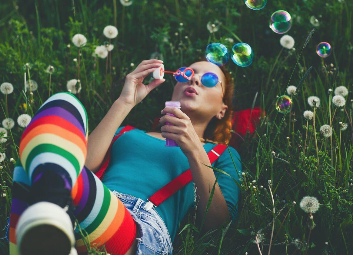 Image of colorfully-dressed woman blowing bubbles.