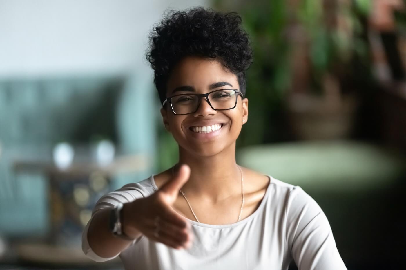 Photo of woman extending her hand in welcome gesture.