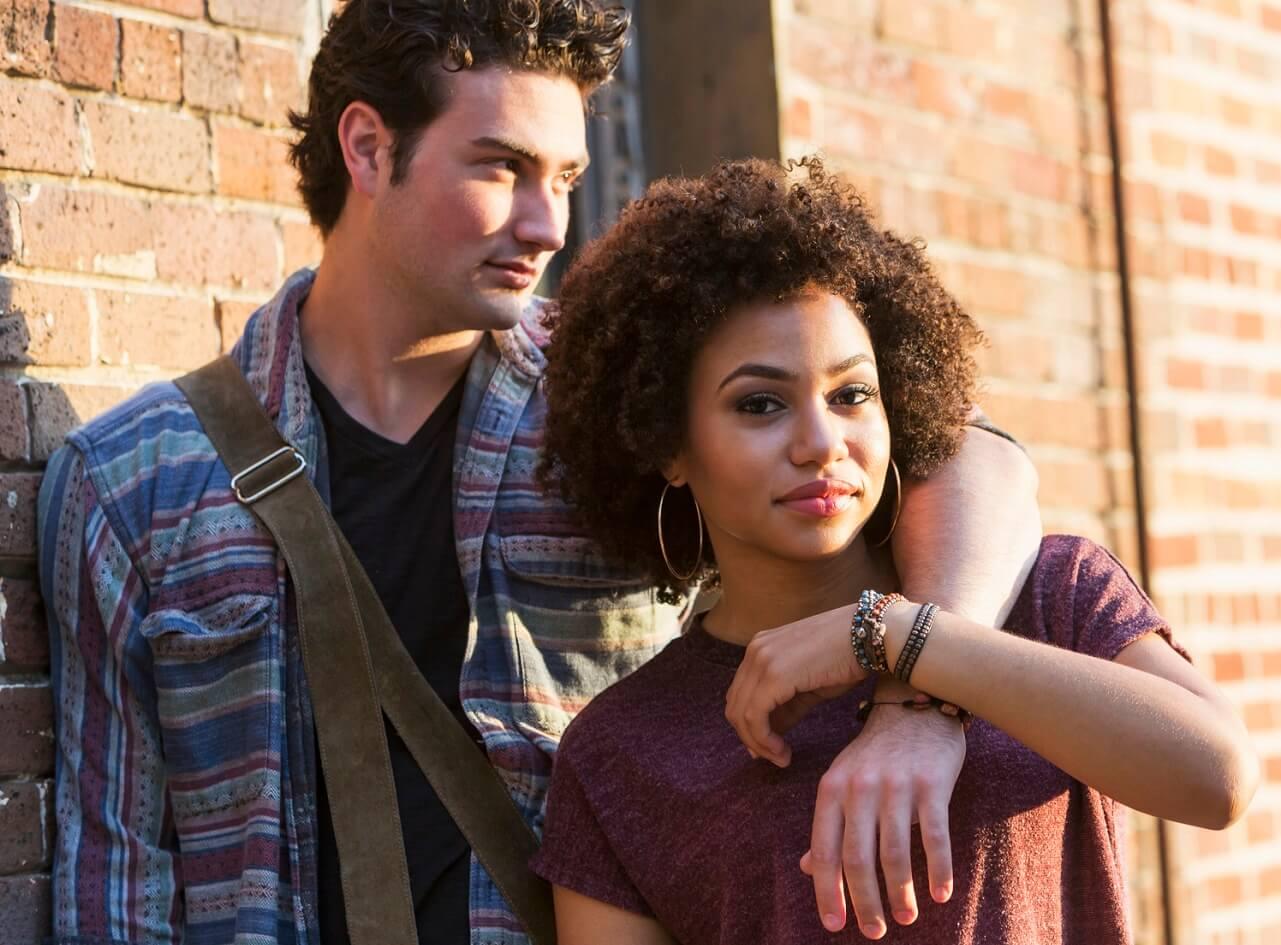 Photo of young couple with their arms around each other.