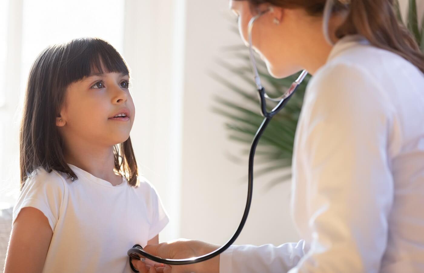 Photo of health care provider listening to child breathing with stethoscope.