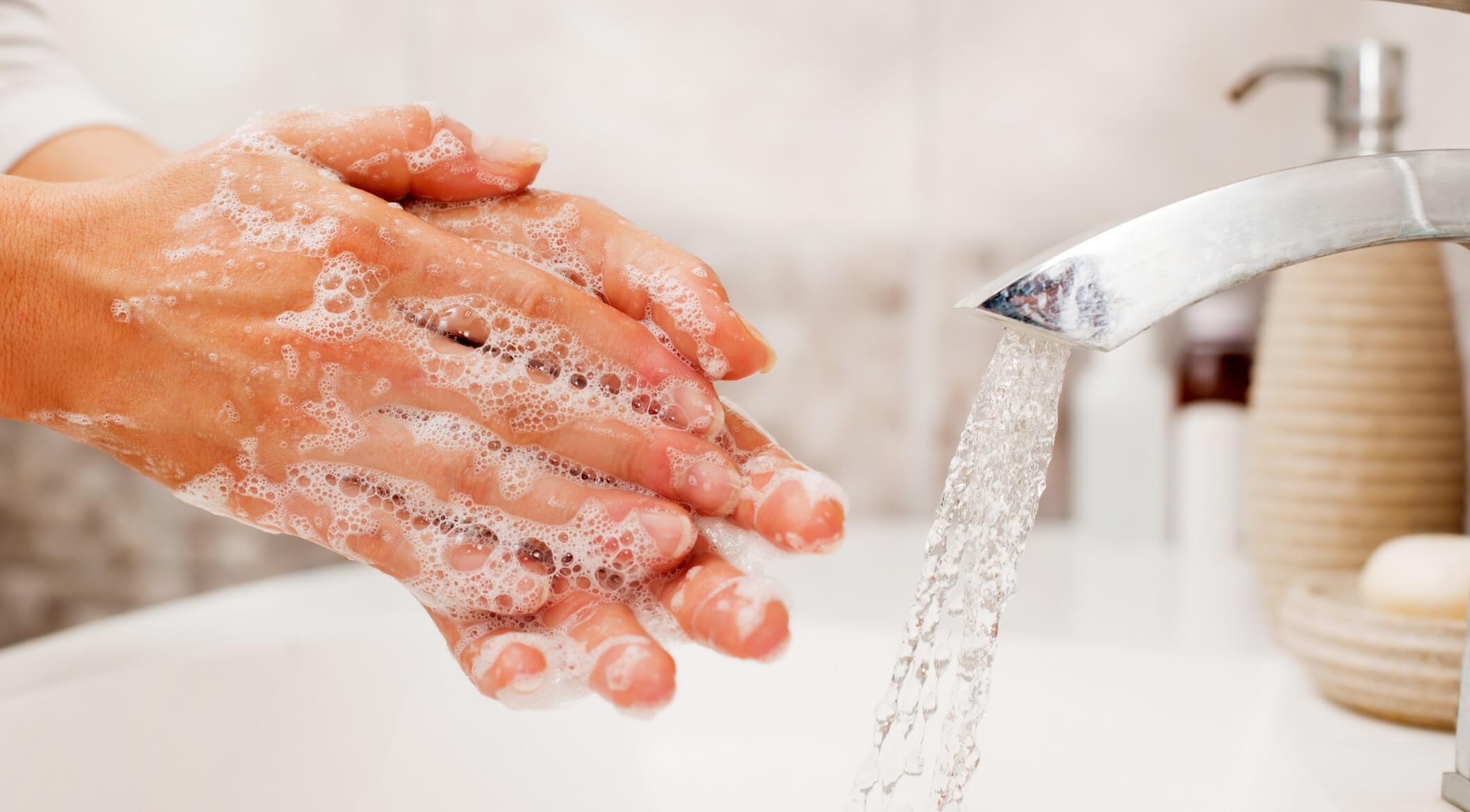 Photo of person washing hands with soap