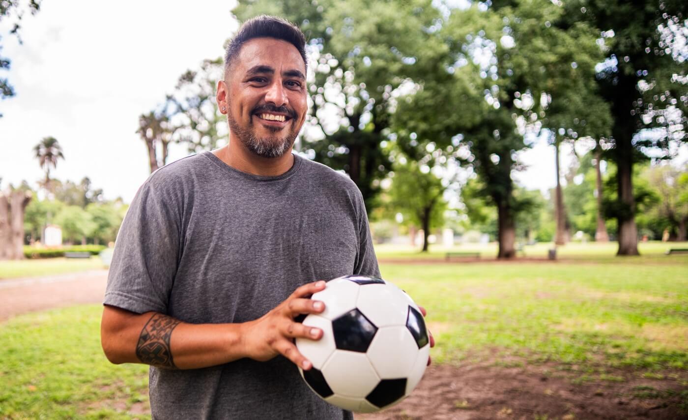 Adult man with soccer ball at park